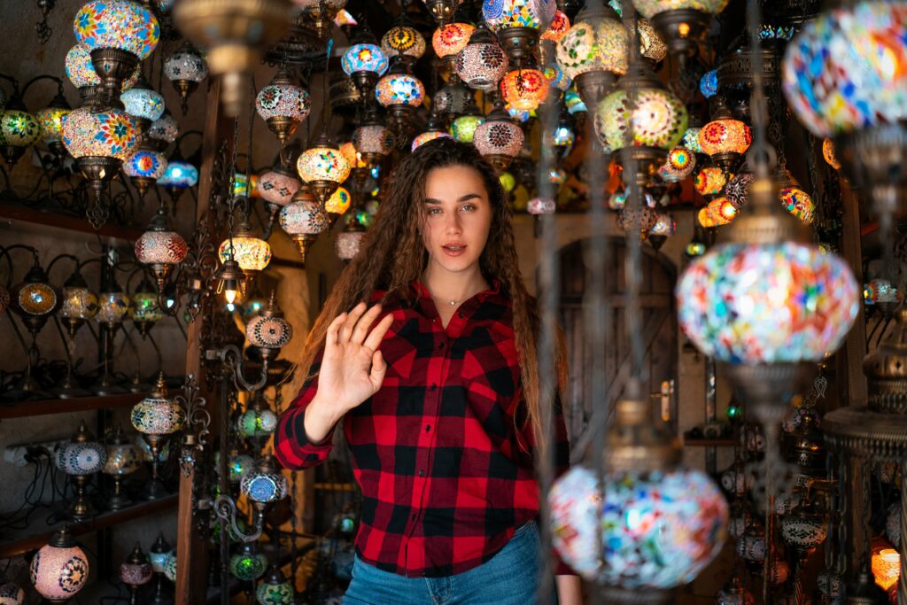 Lantern Lighting Decor Ideas: Creating a Warm, Cozy, and Stylish Ambiance for Modern Homes Young woman in casual attire posing among vibrant Turkish lamps in Göreme, Turkey.